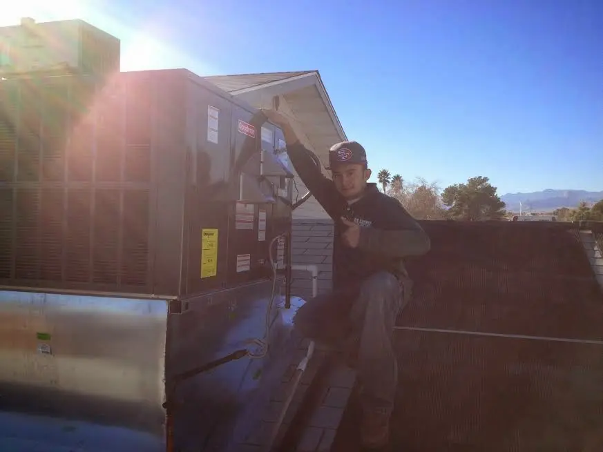HVAC technician performing AC Tune-Up on a rooftop unit in Carbondale